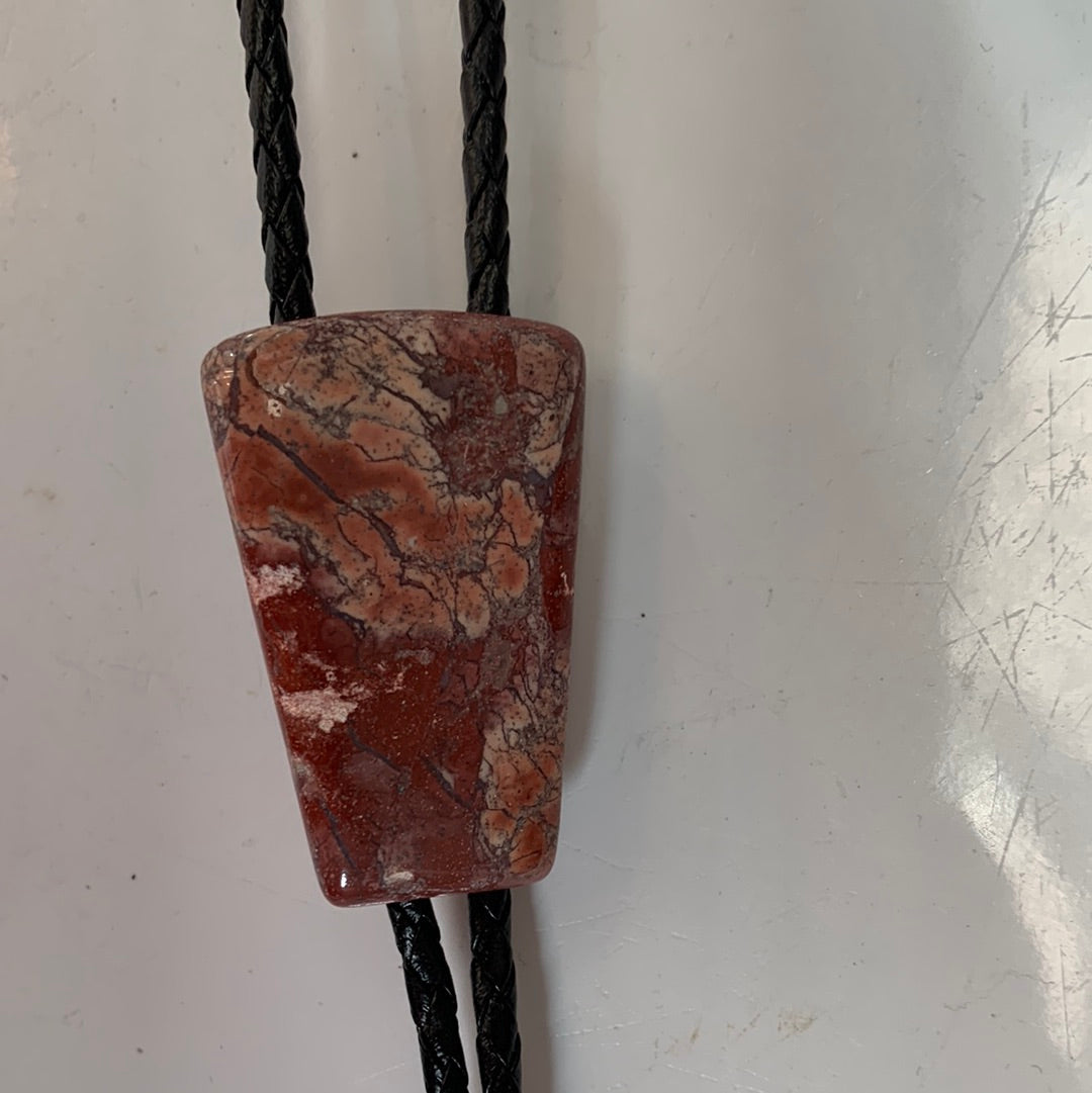Polished red stone bolo with black leather tie