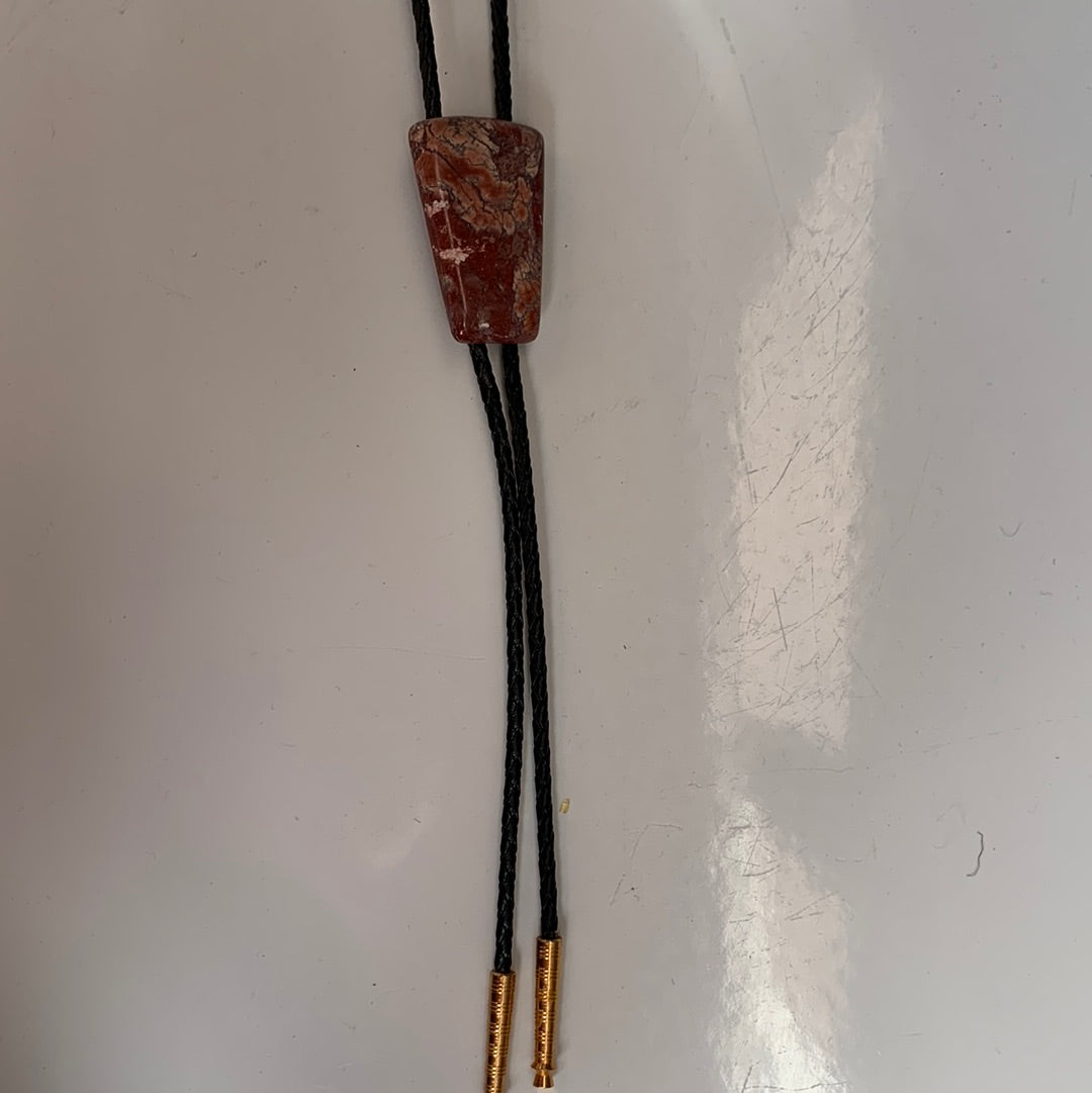 Polished red stone bolo with black leather tie