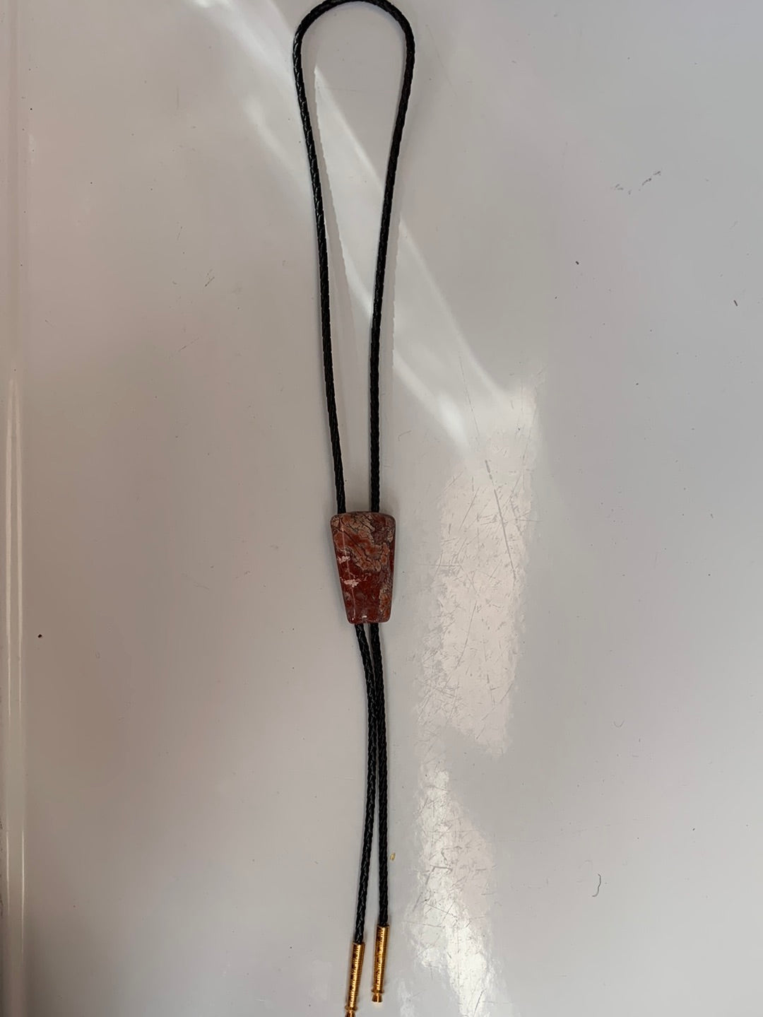 Polished red stone bolo with black leather tie