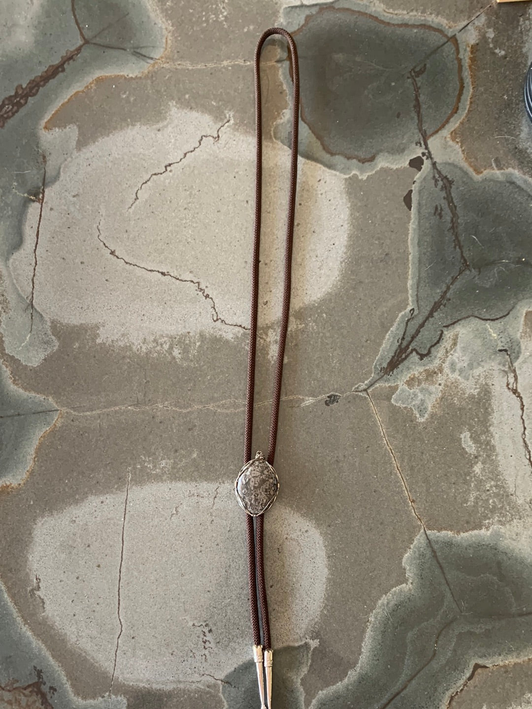 Grey silver wrapped stone bolo with brown cord