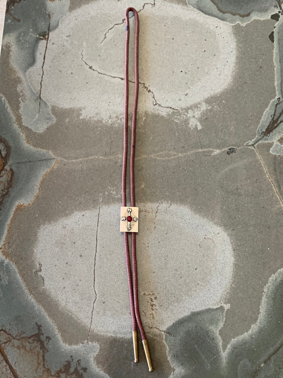 Silver compass with brown cord