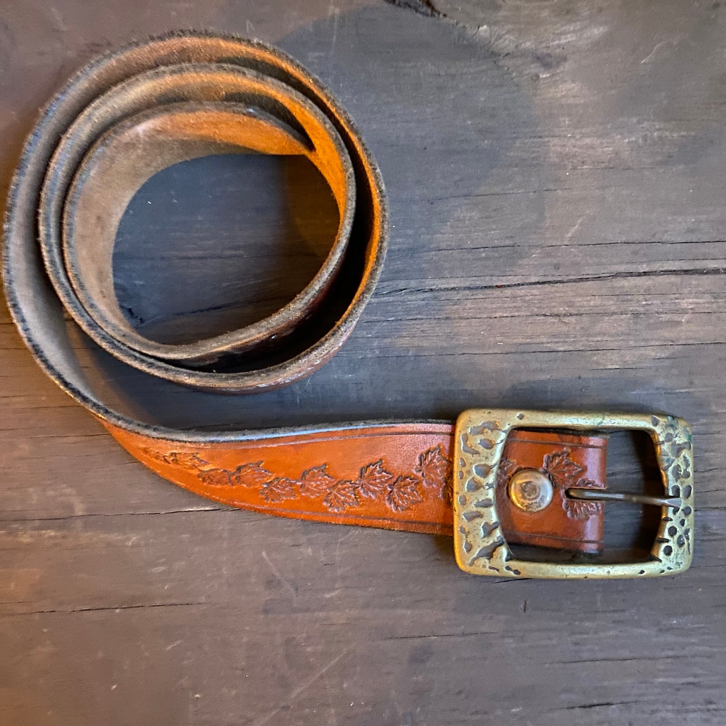 Leaf motif tooled leather belt with brass buckle