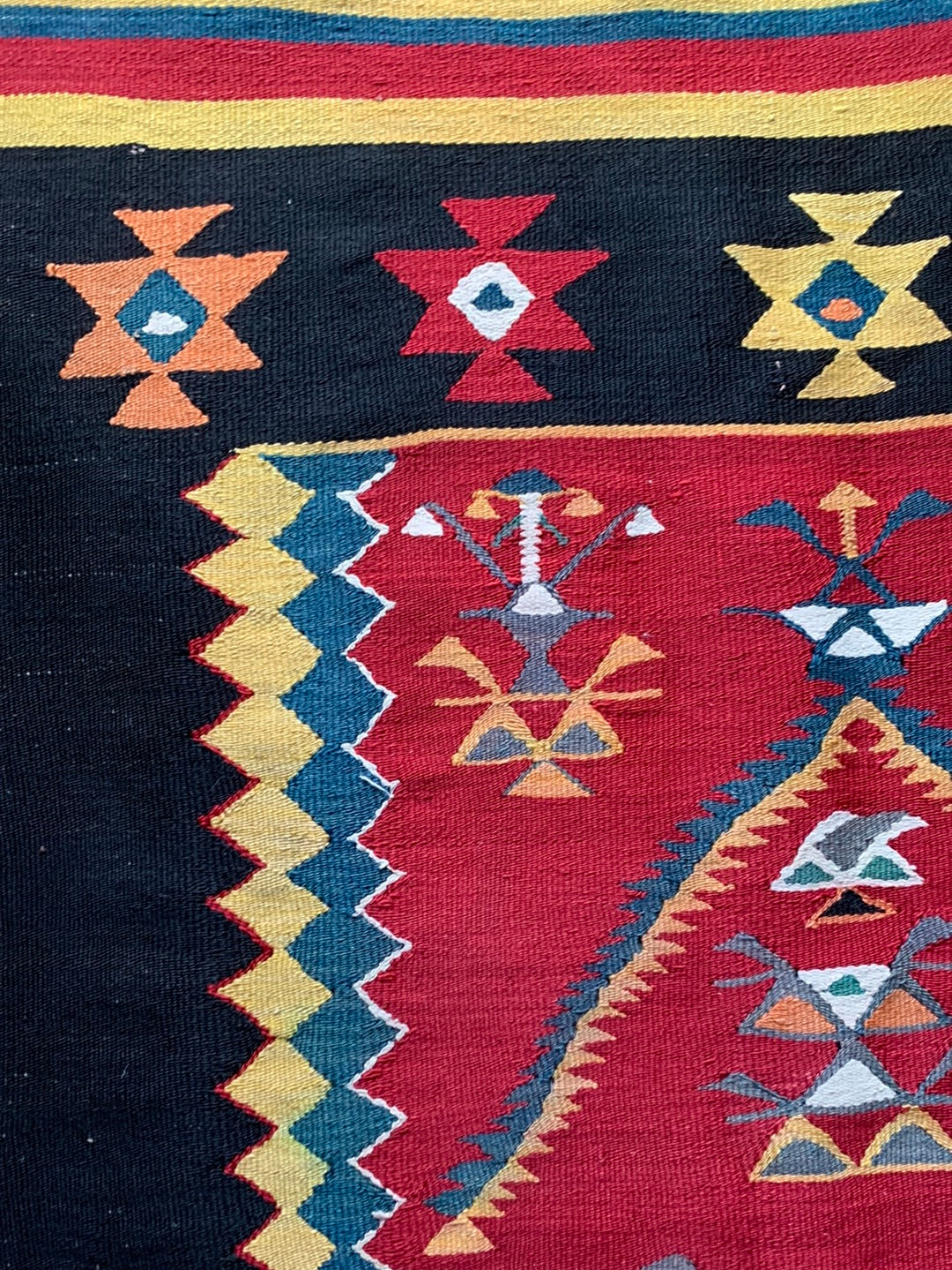 Red, yellow & teal rug with black border