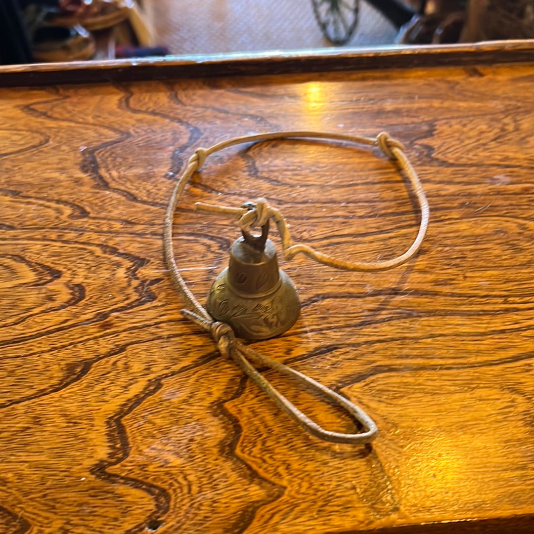 Small metal bell with leather cord
